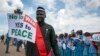 South Sudanese people hold signs as they await the arrival back in the country of South Sudan's President Salva Kiir, at the airport in Juba, South Sudan, June 22, 2018.