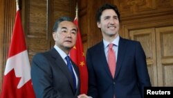 PM Kanada, Justin Trudeau (kanan) bersama Menlu China Wang Yi di Ottawa, Ontario, Kanada (1/6).