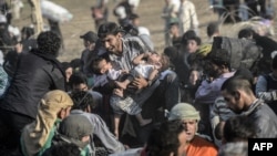 14일 터키와 시리아 국경 지역에서 폭력사태를 피해 달아난 시리아 난민들이 찢어진 철책을 뚫고 들어고 있다. 