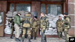 FILE - Pro-Russian rebels stand outside the Zasyadko coal mine in Donetsk, Ukraine.