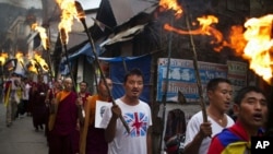 Exile Tibetans carry torches as they participate in a candlelit vigil in Dharmsala, India, June 21, 2012.
