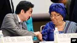 Japanese Prime Minister Shinzo Abe, left, shakes hands with Liberian President Ellen Johnson Sirleaf at a symposium on human security held on the sidelines of the Tokyo International Conference on African Development in Yokohama, Japan, June 2, 2013.