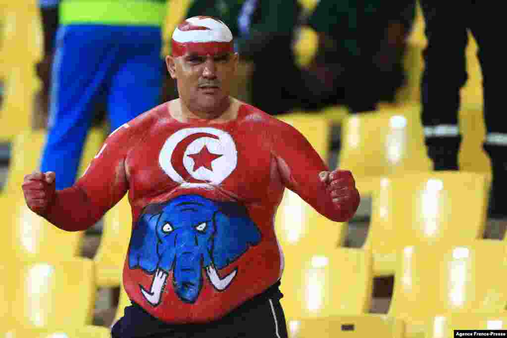 A Tunisia&#39;s fan with the body painted with his national flag and a blue elephant gestures before the match against Burkina Faso in Cameroon, Jan. 29, 2022.