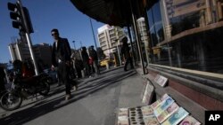 FILE - Iranian banknotes are displayed by a vendor at the side walk of the Ferdowsi Street in Tehran, Jan. 23, 2013.