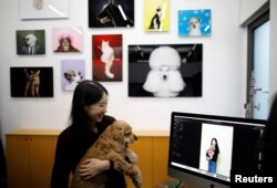 Seorang perempuan melihat foto-foto dirinya dan anjing kesayangannya di sebuah studio di Seoul, Korea Selatan, 17 Januari 2019. (Foto: Reuters)