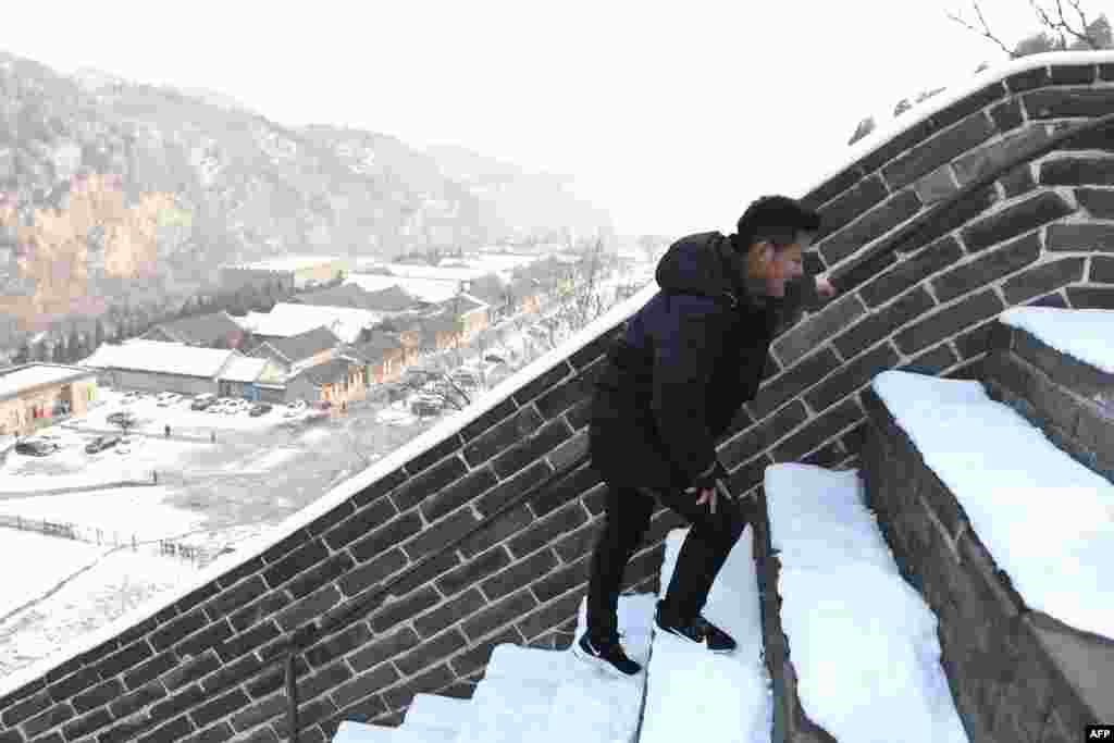 برفباری کے بعد دیوار چین کے زینے عبور کرنا مزید دشوار ہوجاتا ہے۔ ایک سیاح دیوار پر چڑھتے ہوئے تھکاوٹ کا شکار ہے۔ اس کی تھکن چہرے اور باڈی انداز سے بھی واضح ہے۔&nbsp;