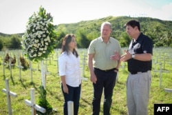 This photo taken on March 12, 2016 shows former US vice-president Al Gore (C) talking to Philippine Senator Loren Legarda (L) and Mayor Alfred Romualdez during a visit to the mass grave for victims of super typhoon Haiyan, in Tacloban City, central Philippines.