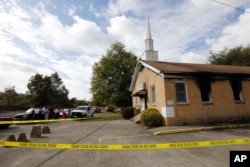 Area residents and church members look on as authorities investigate a fire at Hopewell Baptist Church in Greenville, Mississippi, Nov. 2, 2016. "Vote Trump" was spray-painted on an outside wall of the African American church.