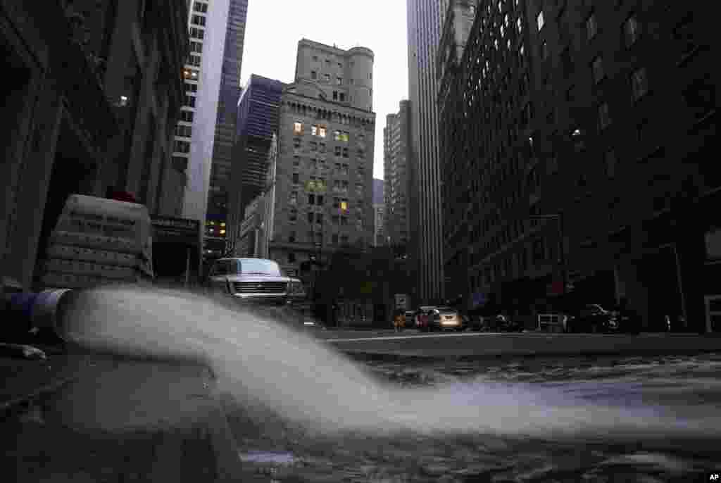 Water gushes from a hose as it is pumped out of a basement in New York's financial district, Oct. 31, 2012.