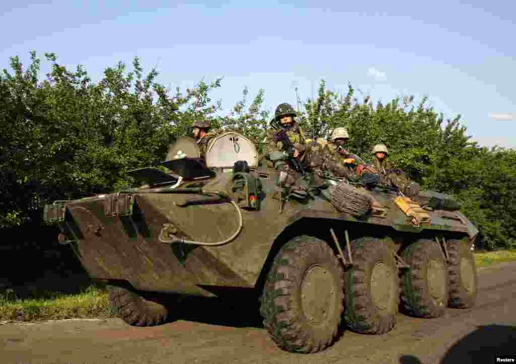 Ukrainian paratroopers ride atop an armored personnel carrier in the village of Starovarvarivka, Ukraine, May 15, 2014. 