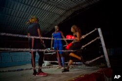 Olympic silver medalist Emilio Correa Jr., center, instructs Idamelys Moreno, right, and Legnis Cala, at a sports center in Havana, Cuba, Jan. 24, 2017.