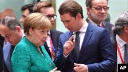 Kanselir Jerman Angela Merkel (kiri) berbicara dengan Kanselir Austria Sebastian Kurz pada pertemuan para pemimpin Eropa untuk membahas isu migrasi di Brussels, Belgia hari Kamis (28/6). 