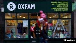 FILE - A pedestrian walks past a branch of Oxfam, in London, Britain.
