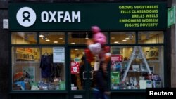 Logo OXFAM devan yon libreri òganizasyon an genyen nan Glasgow, Peyi Lekòs. Gouvènman britanik la anonse, nan jounen 9 fevriye 2018 la, li pral pase an revi finansman li bay OXFAM Oxfam aprè nouvèl fin parèt pou di òganizasyon byenfesans la te itilize sèvis fanm movez vi ann Ayiti. (Foto: 10 fevriye 2018).