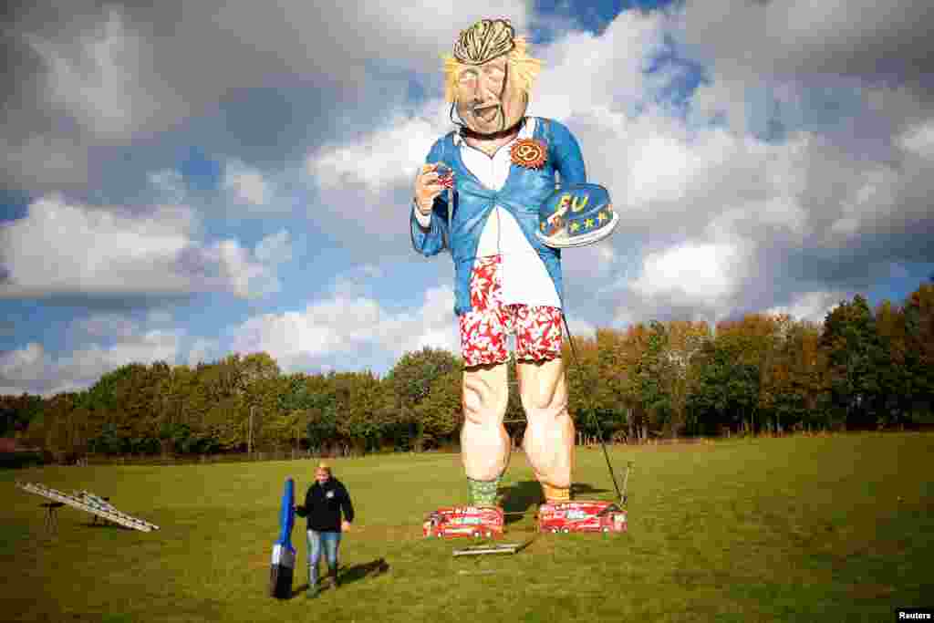 Artist Andrea Deans poses with the 11-meter effigy of Boris Johnson unveiled ahead of the Edenbridge Bonfire Celebrations in Edenbridge, Britain.