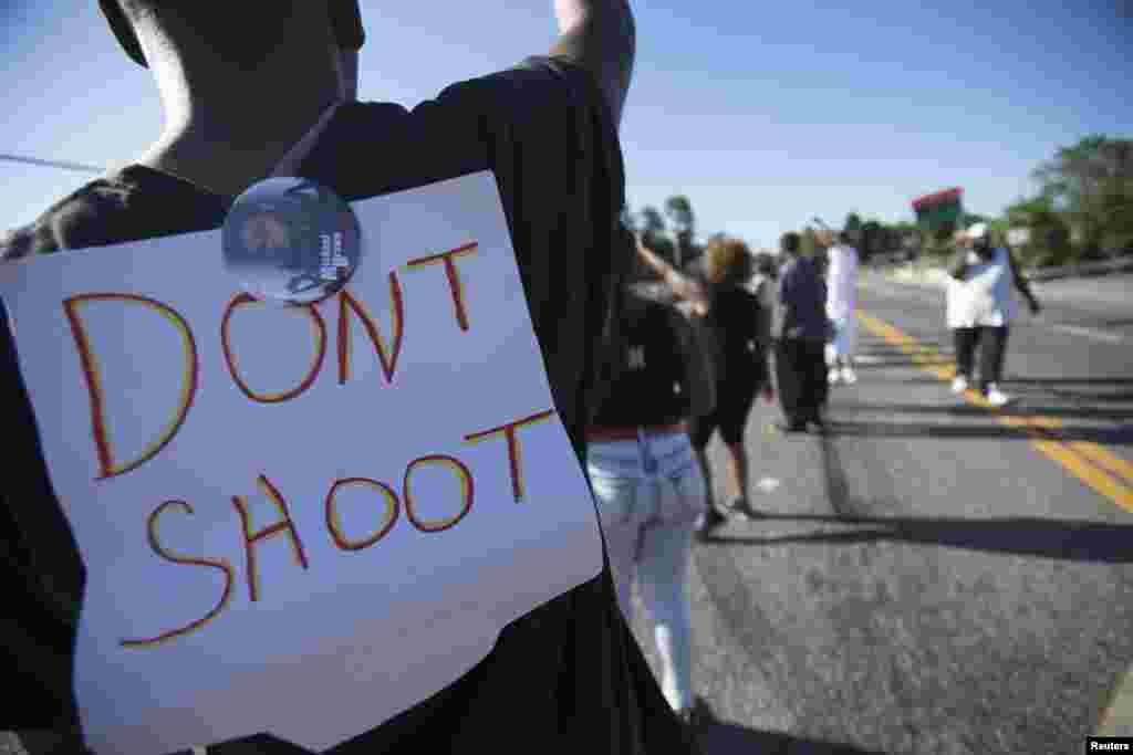 Um manifestante usa um cartaz nas costas que diz &quot;Não dispare&quot;, durante a manifestação contra a morte a tiro do jovem Michael Brown, em Ferguson, Missouri, Ago. 13, 2014.