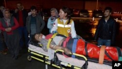 29일 터키 남부 아다나 주의 학교 기숙사에 화재가 발생한 가운데 의료진이 부상당한 학생을 구급차에 싣고 있다.