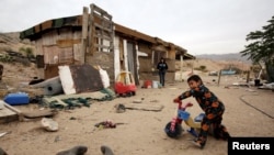 A child plays as his mother looks on outside their house in an impoverished neighborhood in Ciudad Juarez, Dec. 5, 2017. Over 40 percent of Mexicans live below the poverty line.