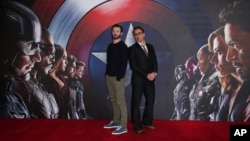 Chris Evans, left, and Robert Downey Jr. pose for photographers at the photo call of the film "Captain America Civil War" in London, April 25, 2016.