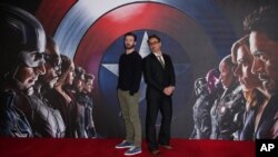 Chris Evans, left, and Robert Downey Jr. pose for photographers at the photo call of the film "Captain America Civil War" in London, April 25, 2016.