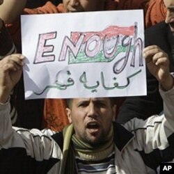 A Libyan protester holds up a sign against Libyan Leader Moammar Gadhafi during a demonstration, in Tobruk, Libya, February 23, 2011