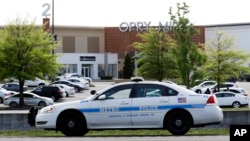 Un auto de policía vigila frente al centro comercial Opry MIlls en Nashville, Tennessee, el jueves 3 de mayo, después que una persona resultó herida en un tiroteo.