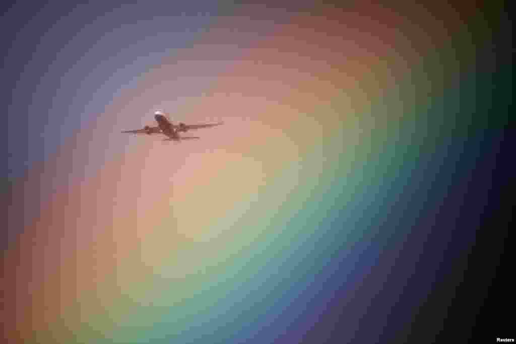 A British Airways aeroplane flies near a rainbow on its way to Heathrow Airport in London, Britain.