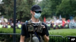 یک عضو گروه راست های افراطی در مقابل کاخ سفید و حضور مخالفان این گروه در زمینه عکس