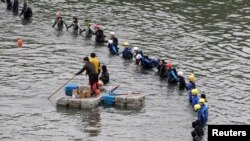 Emergency personnel search the water near the site of the crashed TransAsia Airways plane in New Taipei, Feb. 6, 2015.