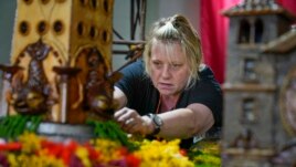 Stephanie Winters fills in the landscaping around a Coney Island themed display, Nov. 11, 2021.