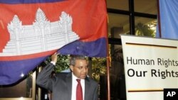 UN special rapporteur Surya Subedi walks through a Cambodian national flag upon his arrival in a conference room at the UN headquarter in Phnom Penh.