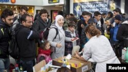 Volunteers distribute food and drinks to migrants who arrived at Malmo train station in Sweden on the morning of Sept. 10, 2015. 