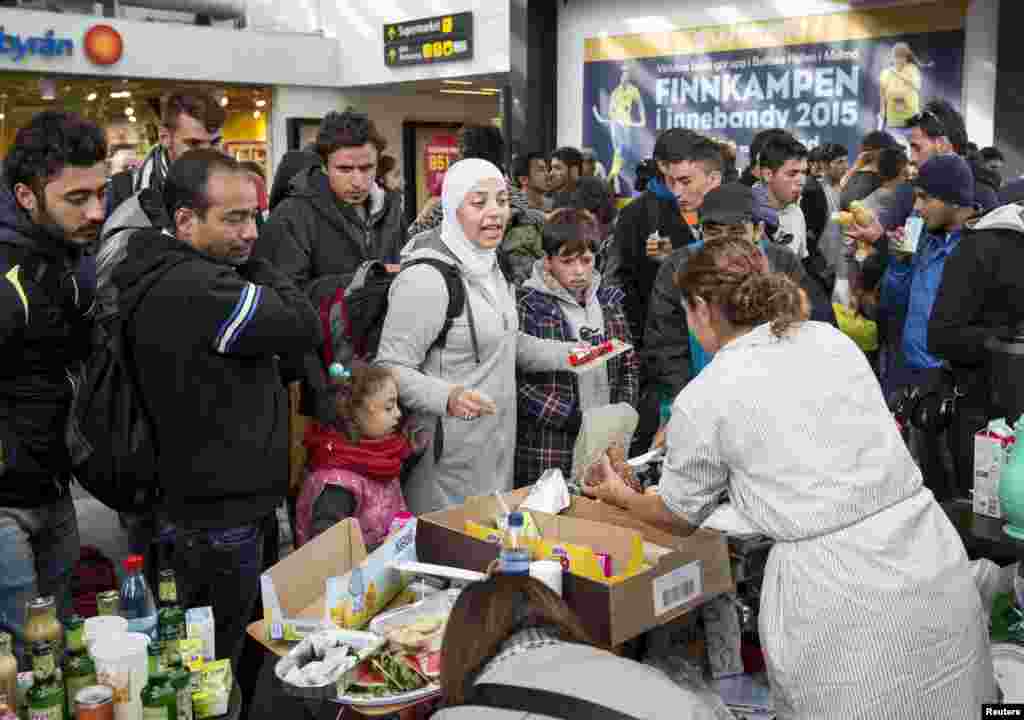 In Sweden, volunteers distribute food and drinks to migrants who arrived at Malmo train station.