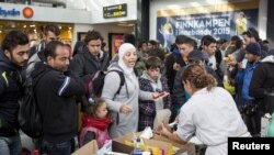 Tenaga sukarela membagikan makanan dan minuman bagi para migran yang tiba di stasiun kereta Malmo, Swedia, September 2015.