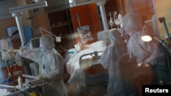 အီတလီနိုင်ငံ ရောမမြို့ရှိ Casalpalocco ဆေးရုံ အရေးပေါ်ခန်းတွင် ကိုရိုနာဗိုင်းရပ်စ် ကူးစက်လူနာအား ပြုစုကုသနေသည့် ဆေးဝန်ထမ်းများ။ (မတ် ၂၄၊ ၂၀၂၀)