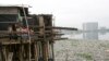 Anak-anak berdiri di dalam rumahnya di atas danau yang tercemar sampah di kawasan kumuh, Jakarta Utara. (Foto: REUTERS/Supri)