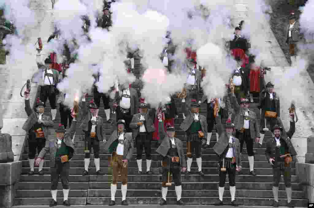 Bavarian riflemen and women in traditional costumes fire their muzzle loaders in front of the 'Bavaria' statue in Munich, southern Germany, Oct. 6, 2013. 
