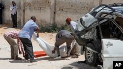 Le corps de l'ancien ministre de la Défense somalien Muhyadin Mohamed Haji porté par des secours au lieu où une bombe placée dans sa voiture a explosées à Mogadiscio, Somalie, 15 février 2016.