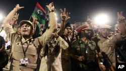 Fighters with Libya's interim government celebrate at Martyrs' Square in Tripoli October 20, 2011.