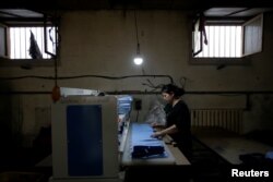 FILE - A woman works at a shoe factory in Santai, Hebei province, China. April 6, 2017.