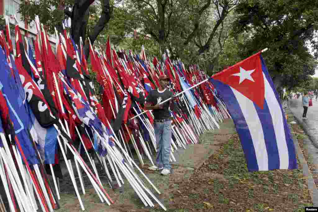 Seorang pria memegang bendera Kuba setelah parade Hari Buruh di Havana.