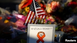 A sign and U.S. flag are pictured at a makeshift memorial in the middle of Las Vegas Boulevard following the mass shooting in Las Vegas, Nevada, Oct. 6, 2017. 
