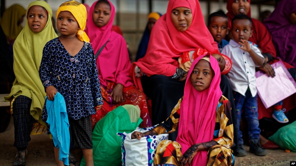 FILE - Some of around 20 Somali refugee families wait to be flown to Kismayo in Somalia, under a voluntary repatriation program, at the airstrip of Dadaab refugee camp in northern Kenya, Dec. 19, 2017.