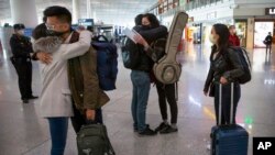 資料照片：被中國官方驅逐的《華爾街日報》記者在飛離中國前在北京的首都國際機場擁抱中國同事。 （2020年3月28日）
