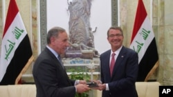 Visiting U.S. Defense Secretary Ash Carter, right, receives a gift from his Iraqi counterpart Khaled al-Obeidi during their meeting at the Ministry of Defense, Baghdad, Iraq, Monday, April 18, 2016. (AP Photo)
