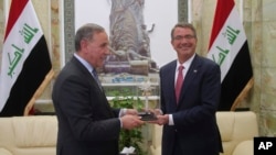18일 이라크를 방문한 애슈턴 카터 미 국방장관(오른쪽)이 칼레드 알-오베이디 이라크 국방장관과의 회담에 앞서 선물을 받고 있다.