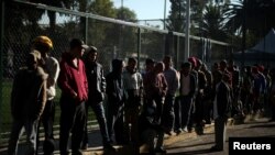 Migrantes de una caravana de miles que viajan desde Centroamérica hacia Estados Unidos, hacen fila para recibir donaciones de comida en un campamento levantado en Ciudad de México. Noviembre 6 de 2018. Reuters/Hannah McKay.