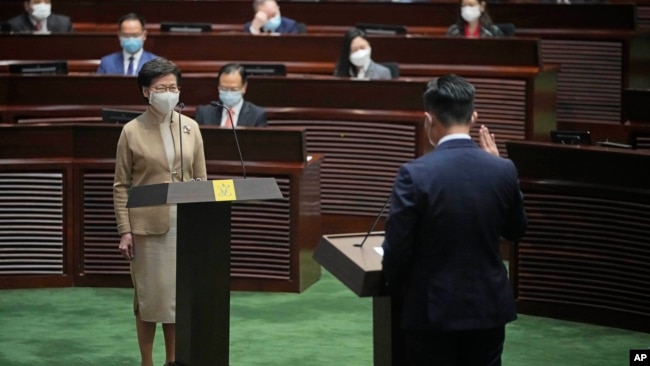 Newly elected pro-Beijing lawmaker Vincent Cheng Wing-shun, right, takes his oath in front of Chief Executive Carrie Lam during the oath-taking ceremony of the legislative council in Hong Kong, Monday, Jan. 3, 2022. (AP Photo/Kin Cheung)