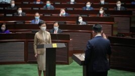 Newly elected pro-Beijing lawmaker Vincent Cheng Wing-shun, right, takes his oath in front of Chief Executive Carrie Lam during the oath-taking ceremony of the legislative council in Hong Kong, Monday, Jan. 3, 2022. (AP Photo/Kin Cheung)