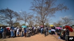 Voters queue to cast their votes at a polling station in Gaberone, Botswana, Oct. 24, 2014.